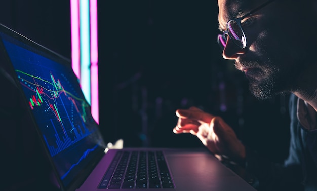 A man analyzing stock market charts financial data on an electronic board