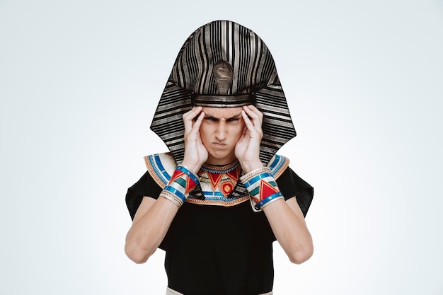 Free photo man in ancient egyptian costume being angry and annoyed touching his temples on white