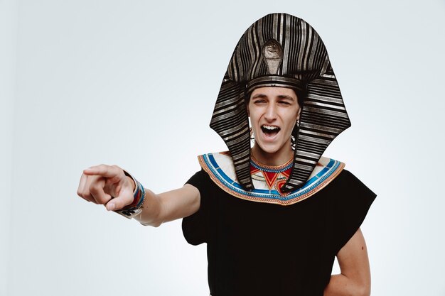 Man in ancient egyptian costume crazy happy laughing pointing with index finger at something on white