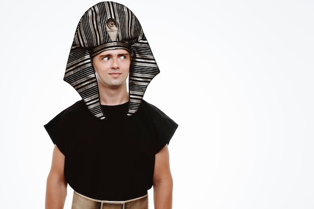 Man in ancient egyptian costume looking aside smiling slyly on white