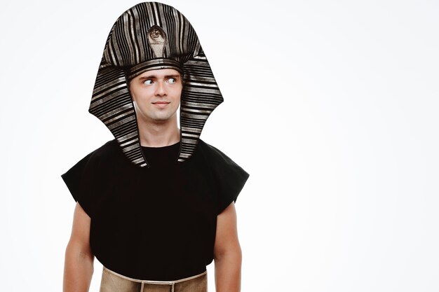 Man in ancient egyptian costume looking aside smiling slyly on white