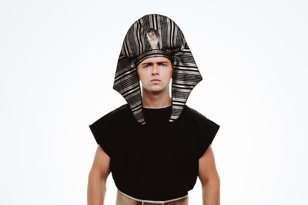 Человек в древнем египетском костюме с серьезным нахмуренным лицом на белом
