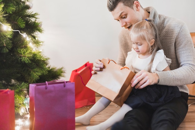 男と娘はクリスマスに贈り物を開く