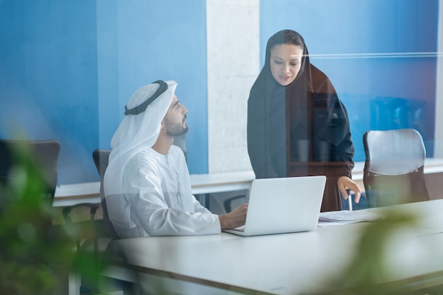 두바이의 비즈니스 사무실에서 일하는 전통 의상을 입은 남녀 프리미엄 사진