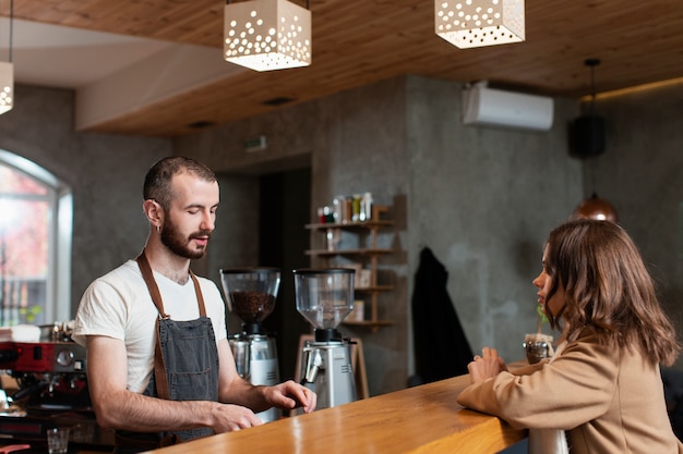 Man in apron preparing coffee for customer