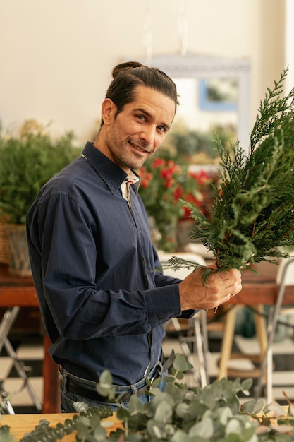 Free photo man arranging plants and looking at camera