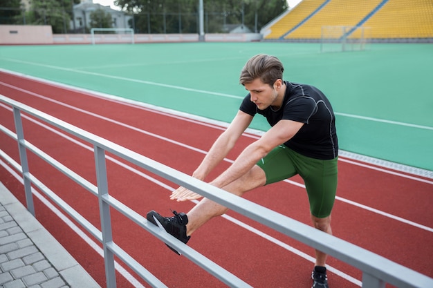 Man athlete make stretching exercises outdoors