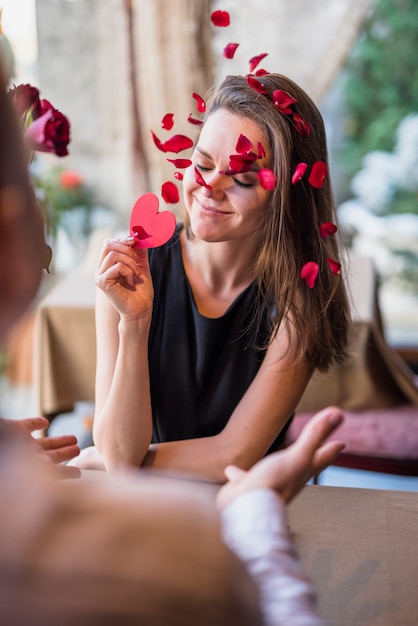 Foto gratuita uomo e donna sorridente attraente con cuore di ornamento al tavolo