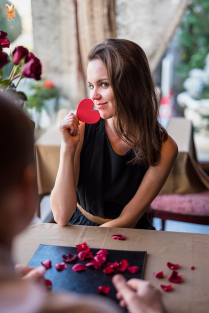 Foto gratuita uomo e donna attraente con cuore di ornamento al tavolo