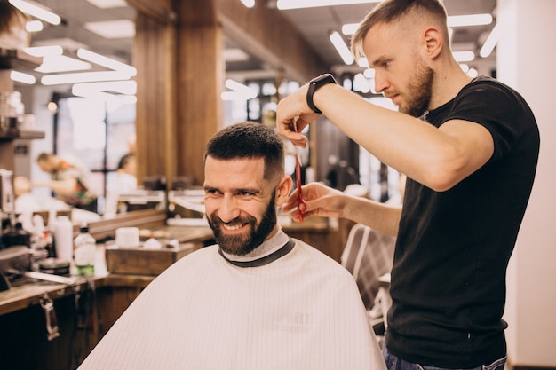 Free photo man at a barbershop salon doing haircut and beard trim