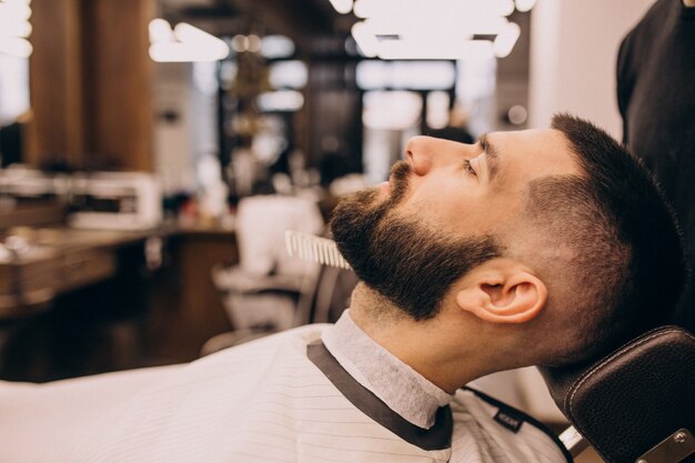 Man at a barbershop salon doing haircut and beard trim