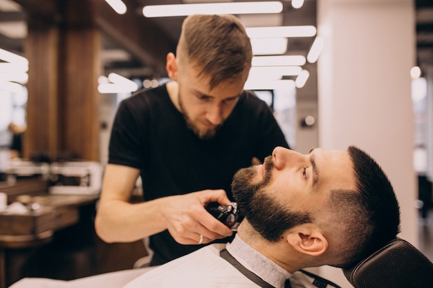 Man at a barbershop salon doing haircut and beard trim