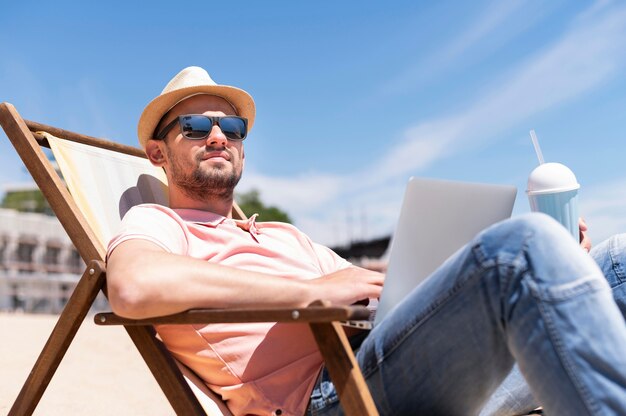 Man in beach chair working with laptop