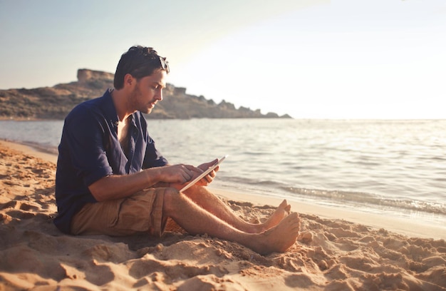 man at the beach with a tablet