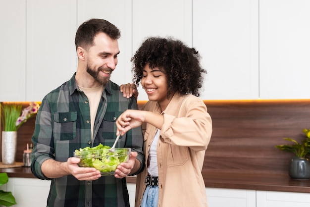 Man and beautiful woman trying tasty salad