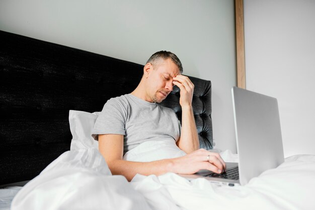 Man in bed using laptop