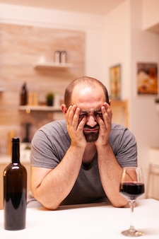 Man being disappointed because of his woman and having alcohol addiction. unhappy person disease and anxiety feeling exhausted with having alcoholism problems.