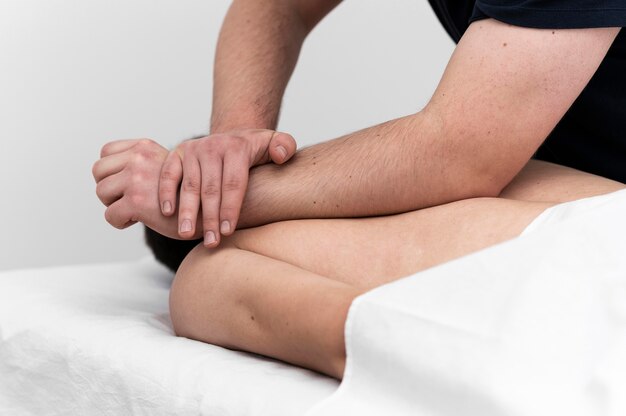 Физиотерапевт делает массаж спины мужчине