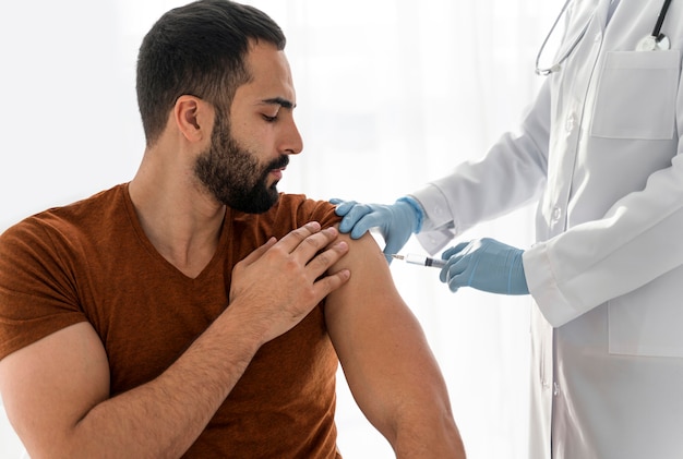 Бесплатное фото Человек вакцинируется врачом