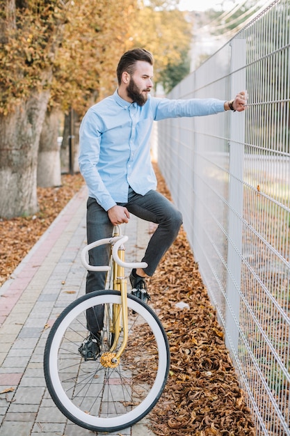 フェンスの近くの自転車にいる男