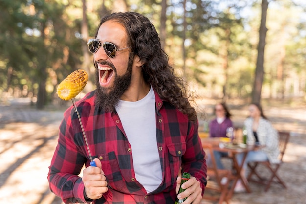 Man biting from a roasted corn outdoors