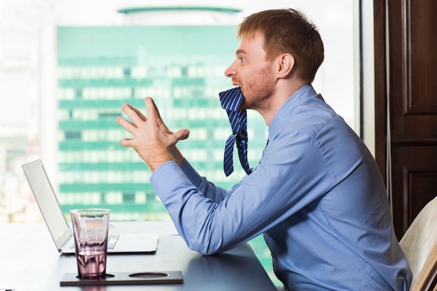 Free photo man biting rabid tie