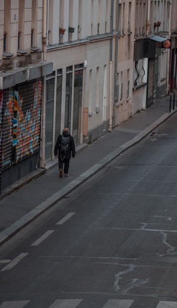 Free photo man in black coat walking on sidewalk