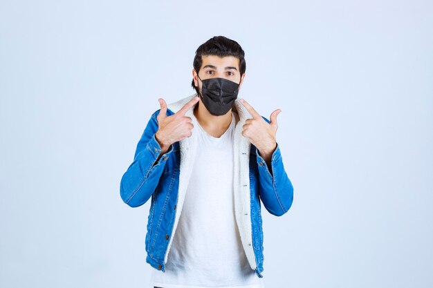 Man in black mask pointing at her mask.