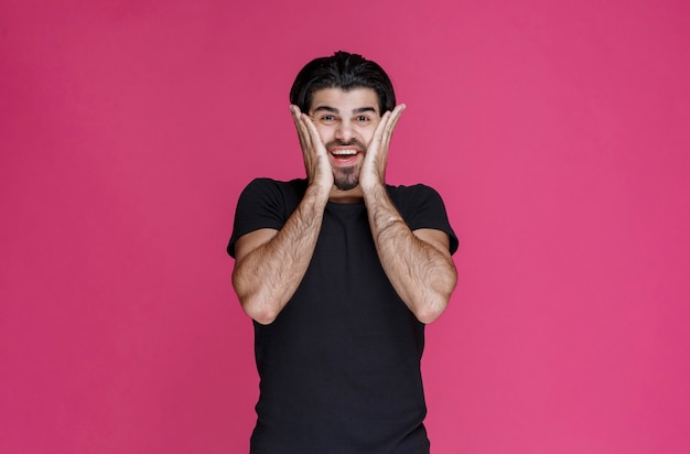 Man in black shirt feels positive about something and enjoys it