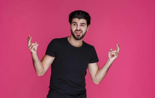 Free photo man in black shirt feels very positive and enjoyed something