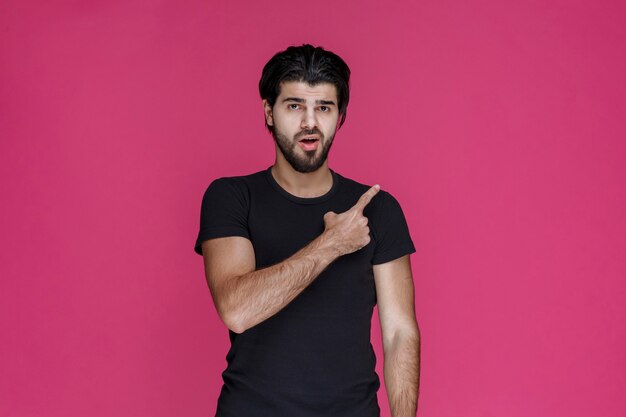 Man in black shirt introducing someone and pointing him