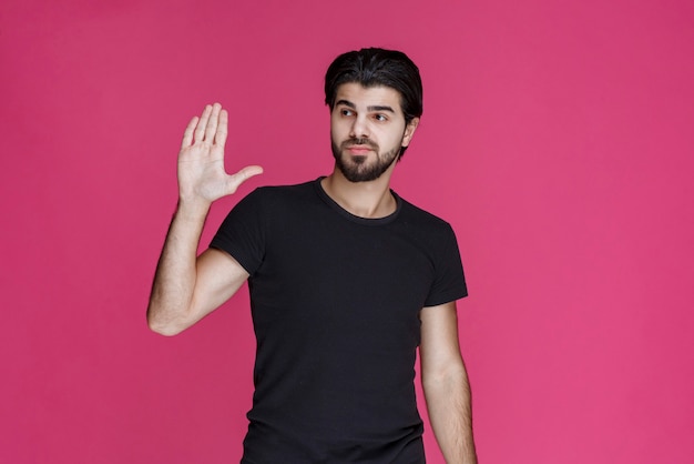 Man in black shirt looks relaxed, cool and flirtatious