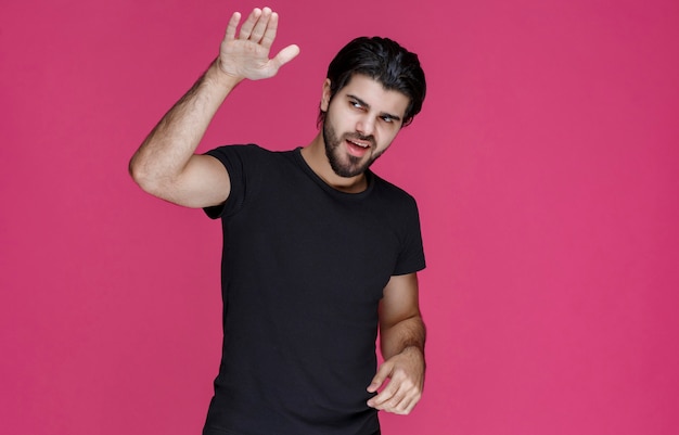 Man in black shirt looks relaxed, cool and flirtatious