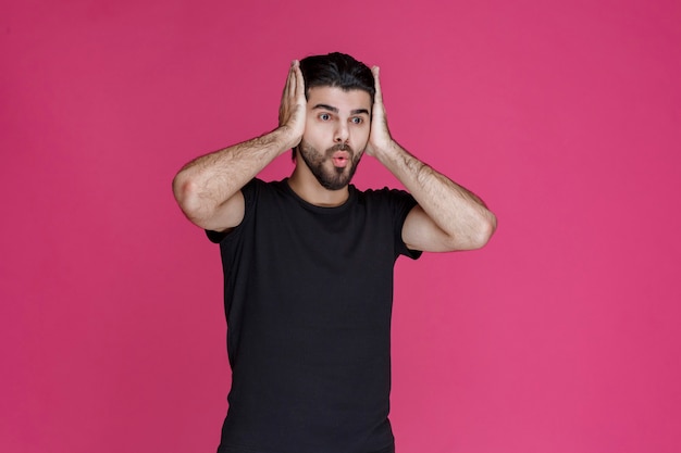 Man in black shirt looks terrified and scared