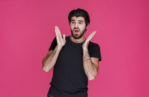 Man in black shirt looks terrified and scared