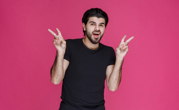 Man in black shirt making peace hand sign