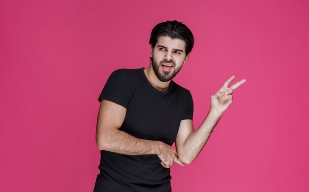 Man in black shirt making peace hand sign