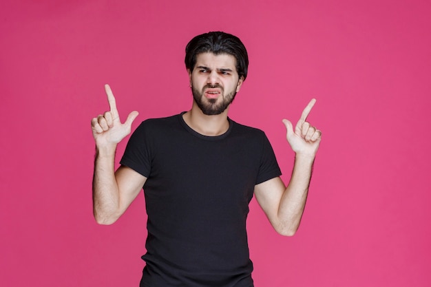 Man in black shirt pointing at something or introducing someone