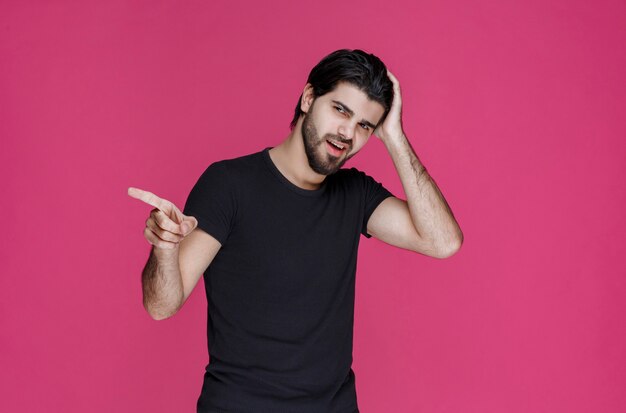 Man in black shirt pointing at something or introducing someone