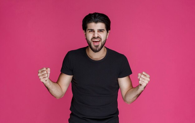 Man in black shirt showing his fist and arm muscles