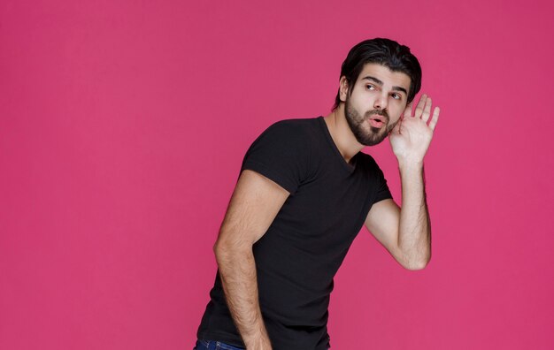 Man in black shirt trying to hear something