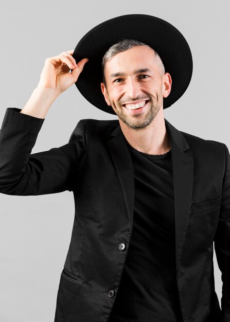 Man in black suit holding his hat