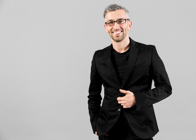 Man in black suit posing in studio