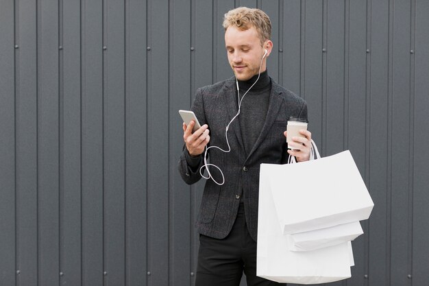 スマートフォンを見てコーヒーと黒の男