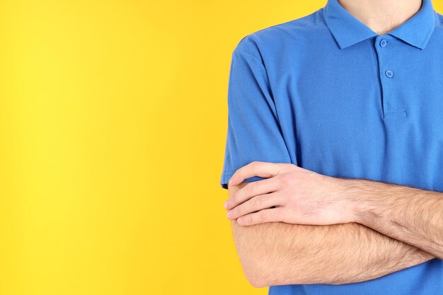 Man in blank blue polo on yellow background