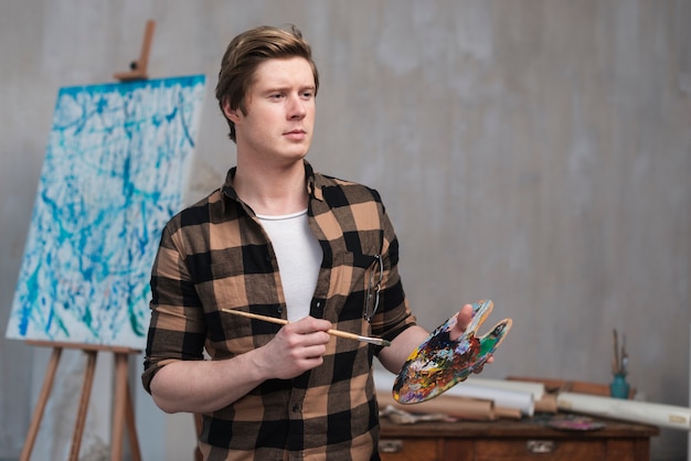 man blending different colors for his painting