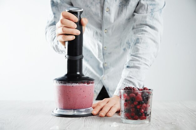 Man blends frozen berries