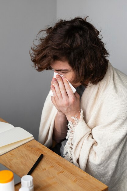 Man blowing his nose indoors