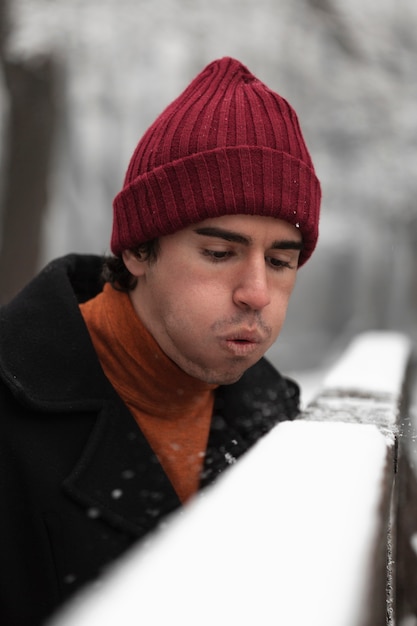 Man blows the snow from a fence