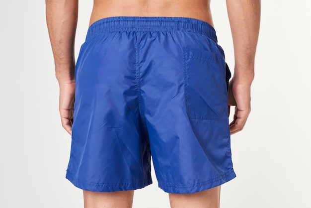 Man in blue board shorts rear view